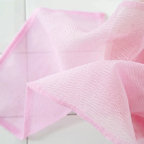 Close-up of pink textured cloths on a light wooden surface