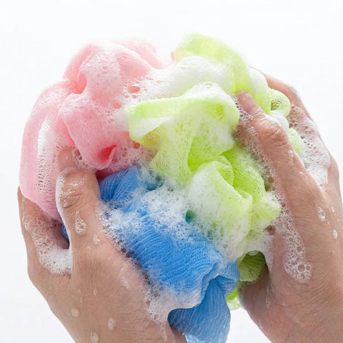 Colorful washcloths with suds held by hands against a white background
