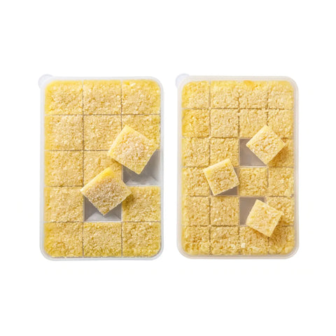 Two containers of minced garlic cubes in a food storage container on a white background