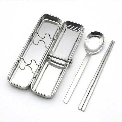 Stainless steel lunch box with spoon and chopsticks on a white background
