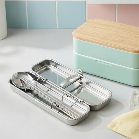 Stainless steel lunch box with cutlery on a kitchen counter
