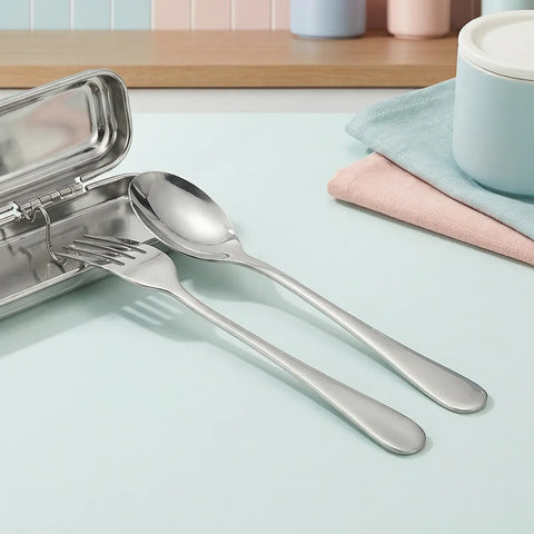 Stainless steel cutlery set with a tin on a light blue surface.