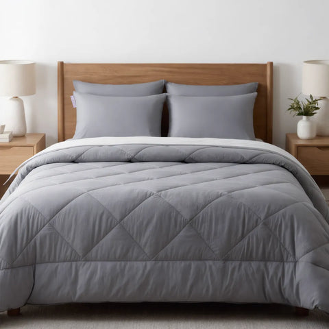 Gray quilted comforter on a bed with wooden headboard and nightstands in a bedroom setting.