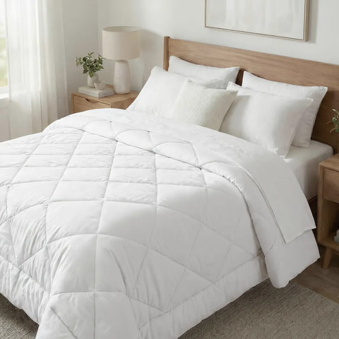 White comforter and pillows on a bed in a bedroom setting