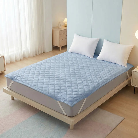 Bed with a blue mattress cover and white pillows in a bedroom setting.