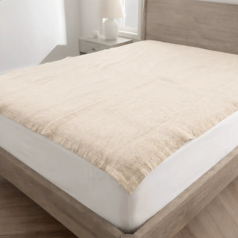 Beige mattress topper on a bed in a bedroom setting