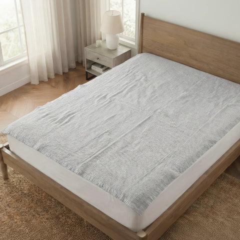 Bed with a gray mattress cover in a bedroom setting
