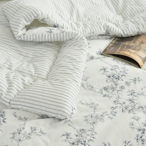 Floral patterned bedding with a striped comforter on top