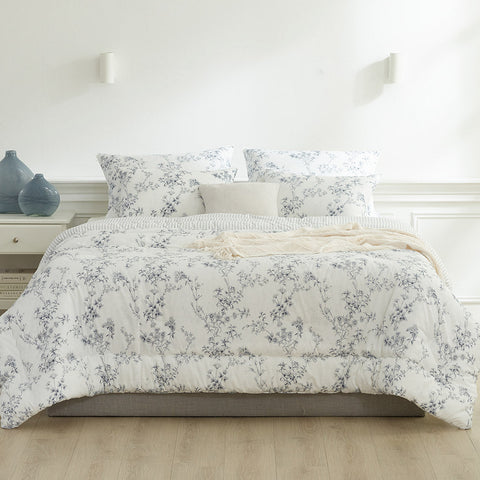 Floral patterned comforter set on a bed in a bedroom setting.