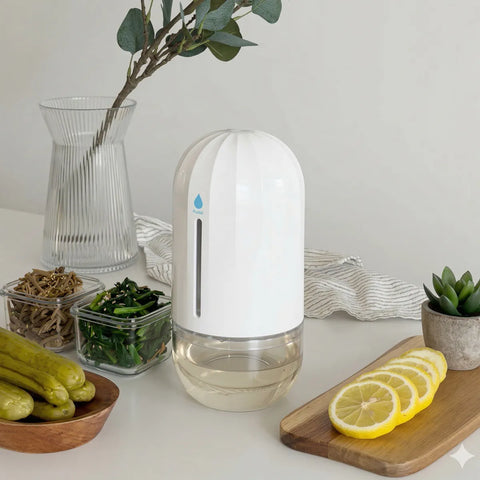 White humidifier on a table with lemons, pickles, and a plant in the background