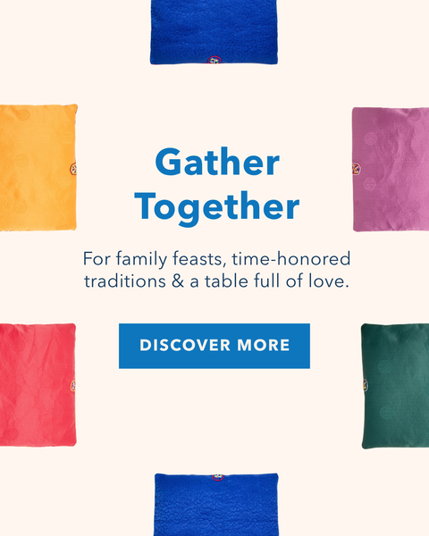 A promotional banner for fabric seat cushions, showing multiple solid-colored square seat cushions in blue, purple, green, orange, red, and pink arranged around centered text that reads 'Gather Together' with a 'DISCOVER MORE' button on a light cream background.