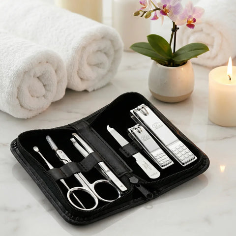 Manicure set in a black case on a marble surface with towels and a candle in the background.