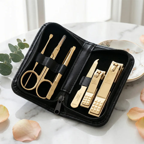 Gold manicure set in a black case on a marble surface with decorative elements.