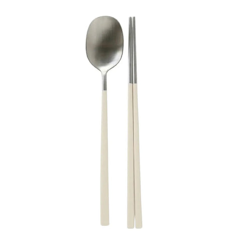 Stainless steel spoon and chopsticks with beige handles on a white background