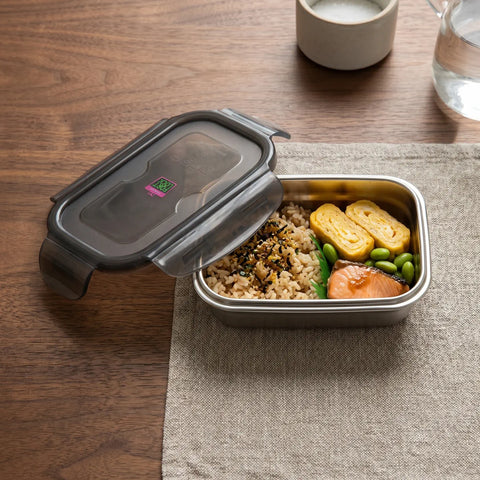 Metal lunch box with food on a wooden table