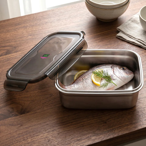 Stainless steel container with fish and lemon on a wooden table