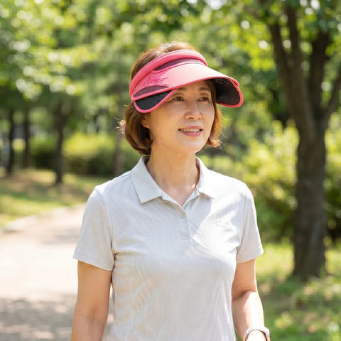 Woman wearing a pink visor in a park setting