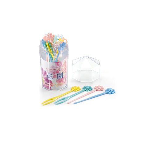 A set of pastel flower-shaped hair picks displayed with their clear cylindrical holder and a small clear geometric box on a white background.