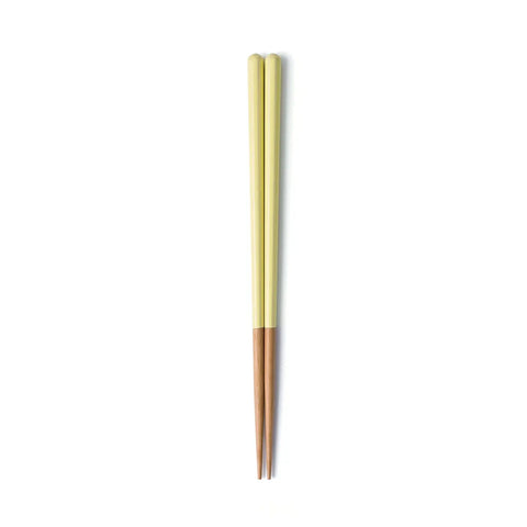 Pair of green and wooden chopsticks on a white background