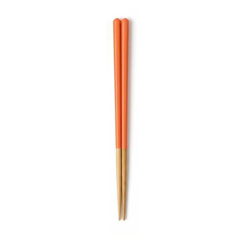 Pair of orange and wooden chopsticks on a white background