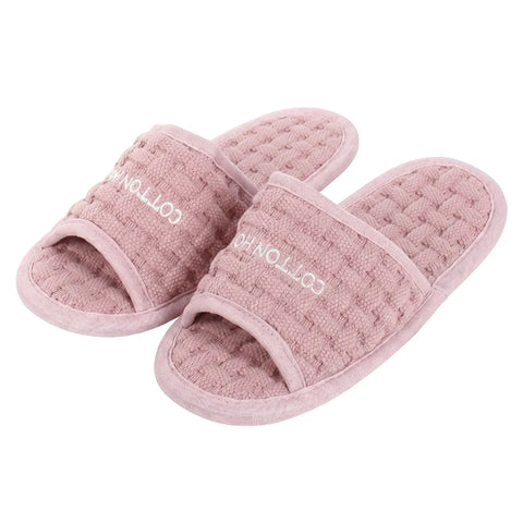 Pair of pink slippers with 'Cotton House' branding on a white background