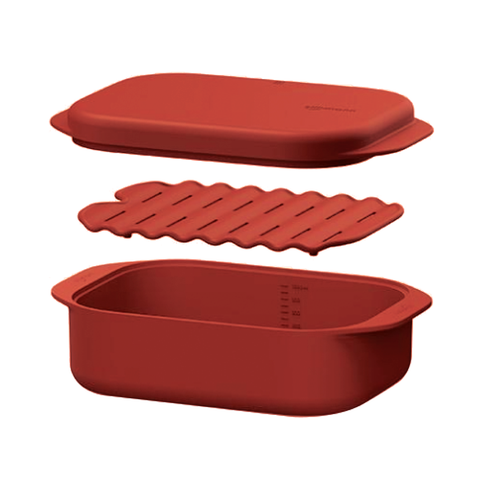 Red silicone steamer dish with lid and rack on a white background