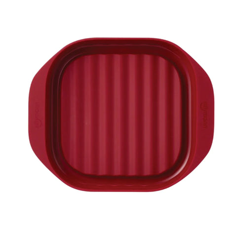 Red silicone baking mat with textured surface on a white background