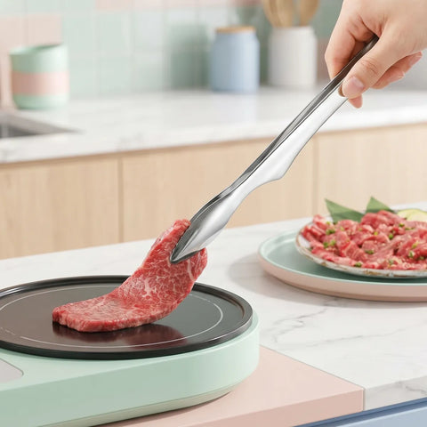 Person using tongs to place raw beef on a small cooktop in a kitchen setting