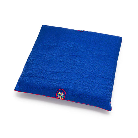 Blue square seat cushion with an embroidered design on a white background