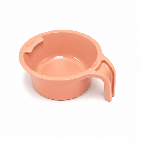 A peach-colored plastic measuring cup with a handle, shown on a clean white background.