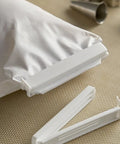White plastic bag clip on a textured surface with a white bag in the background