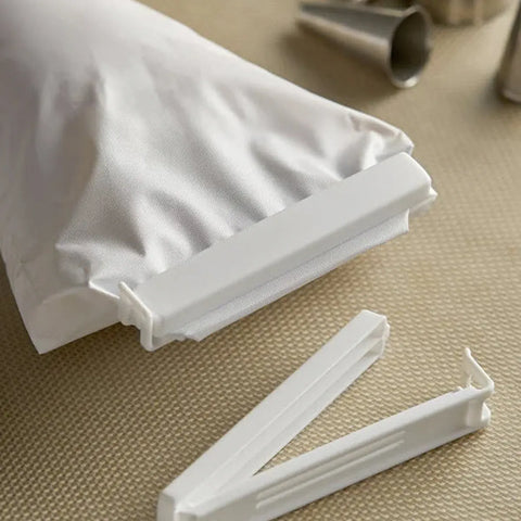 White plastic bag clip on a textured surface with a white bag in the background