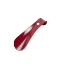 Small red metal shoe horn on a white background