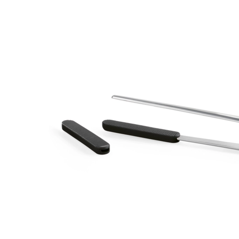 A close-up studio shot of a black textured handle and a long silver tweezers on a plain white background.