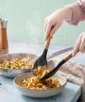 Person using a spatula to serve stir-fry into a bowl on a light blue surface.