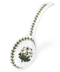 A white ceramic soup spoon with a botanical print featuring green leaves and small white flowers with yellow centers, set against a plain white background.