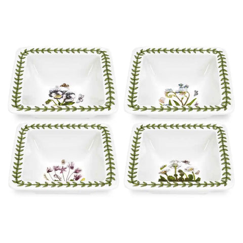 Four white decorative plates with floral designs on a white background