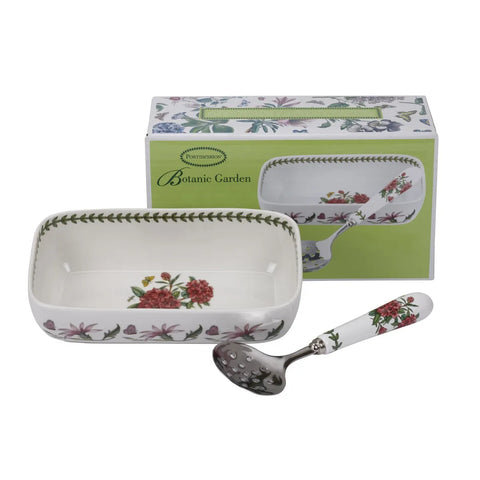 A Porcelain Pattern Botanie Garden serving set featuring a rectangular white ceramic dish with red and pink floral motifs and green leaf borders, accompanied by a matching floral-handled metal spoon and its branded green packaging box.