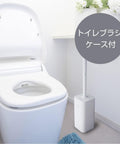 A white toilet brush case standing beside a white toilet in a bright bathroom setting, with a gray circular overlay containing Japanese text.