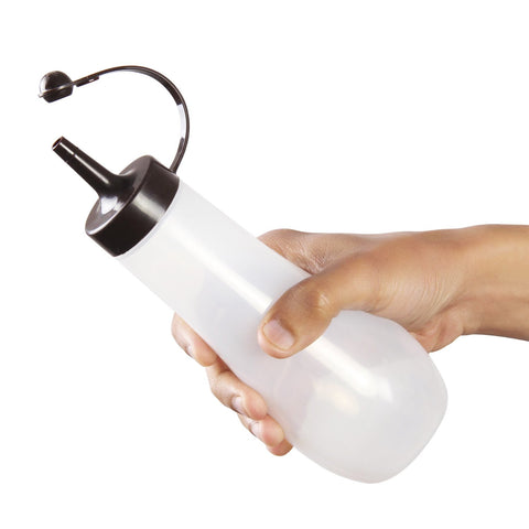 A hand holding a translucent white squeeze bottle with a black nozzle and curved spout against a plain white background.