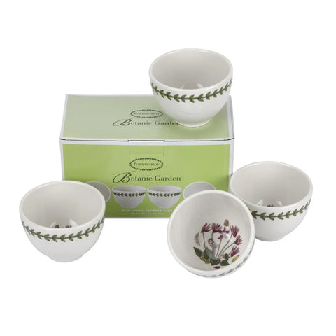 Four white ceramic bowls from the Botanic Garden collection, shown with their light green branded packaging box on a white background. The bowls feature a green leaf border on the exterior and a purple/pink botanical illustration on the interior.