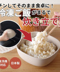 A beige ceramic rice cooker insert bowl filled with cooked white rice, shown on a wooden table with chopsticks lifting the rice. Japanese text overlays explain use, with a circular inset showing the insert being placed into a microwave.
