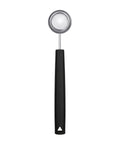 A stainless kitchen measuring spoon with a black handle, shown vertically on a plain white background.