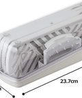 A white plastic mandoline slicer set with a clear plastic lid, shown with dimension lines and labels indicating measurements of 23.7cm length by 8.5cm.