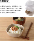 Japanese text at the top and a product photo below showing a small beige ceramic tea bowl filled with white rice, topped with beans and green garnish, with chopsticks and a wooden bowl in a tabletop setting.