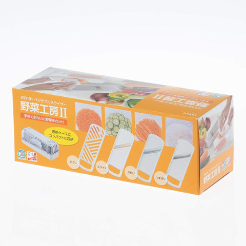Japanese product packaging for a vegetable slicer set, featuring an orange box with illustrations of the slicer and sample cut vegetables, photographed on a white background.
