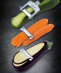 Vegetable peeler with zucchini, carrots, and eggplant on a dark background