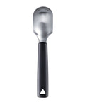 A metal fruit scoop with a black handle, shown vertically against a plain white background.