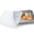 Metal food storage tray with vegetables and a white lid on a white background