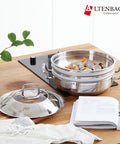 Stainless steel cookware set on a wooden table with Altenbach branding.